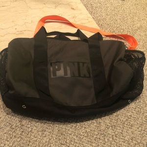 Dark army green duffle with neon orange strap.